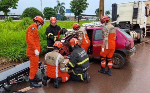 Bombeiros militares socorrem vítima após colisão entre carro e caminhão